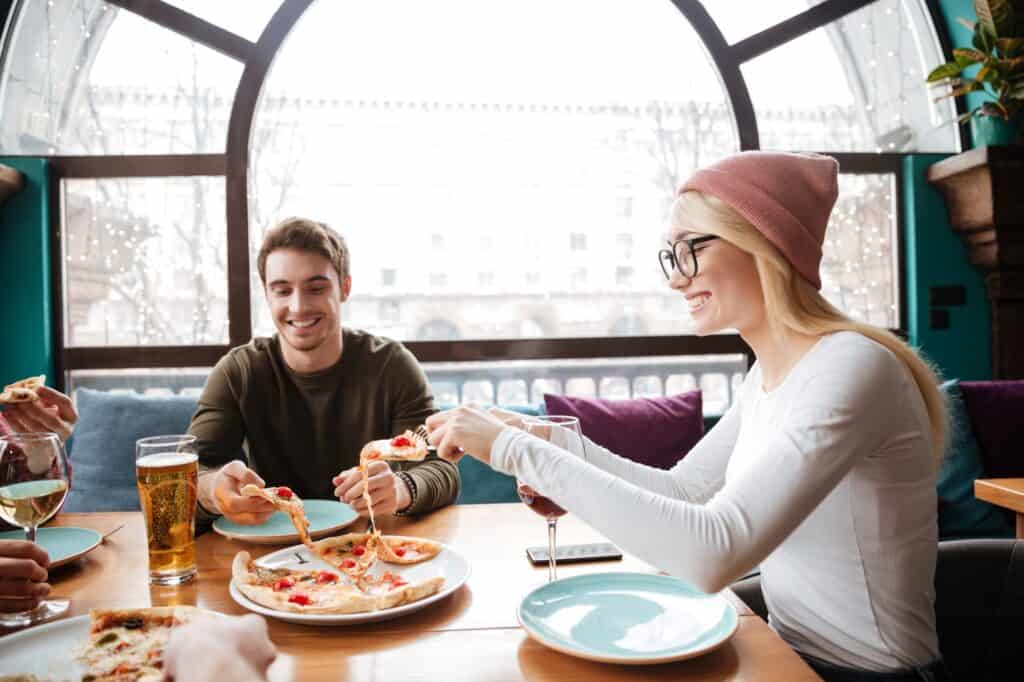 Group of young adults enjoying pizza in a restaurant